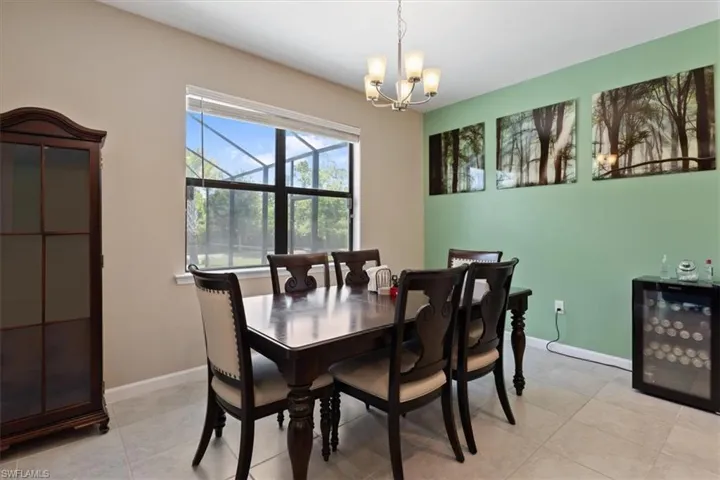 Dining room with beverage cooler, light tile flooring, and an inviting chandelier
