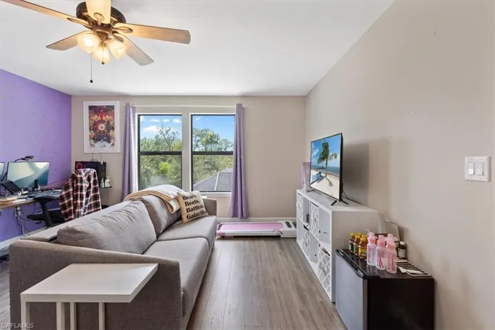 Living room with ceiling fan and hardwood / wood-style floors