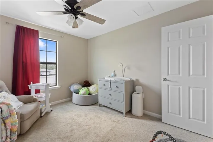 Living area featuring ceiling fan and light carpet