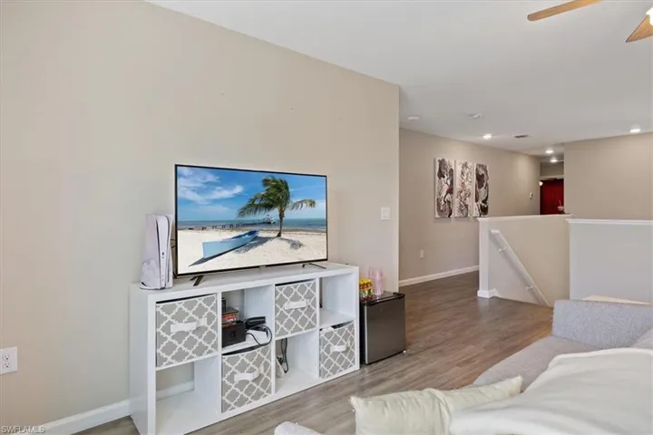 Living room with ceiling fan and light wood-type flooring
