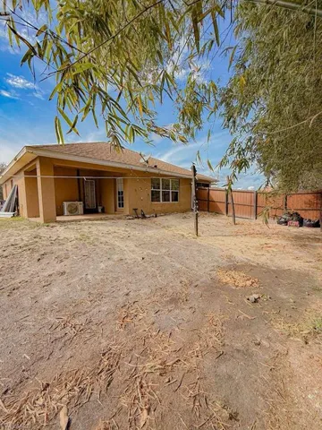 Rear view of house with a patio, stucco siding, a fenced backyard, and roof with shingles