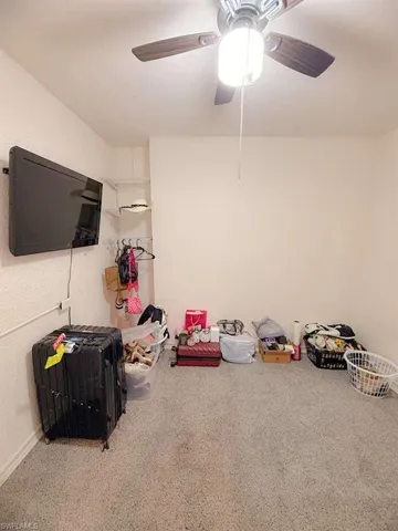 Recreation room featuring a ceiling fan and carpet floors