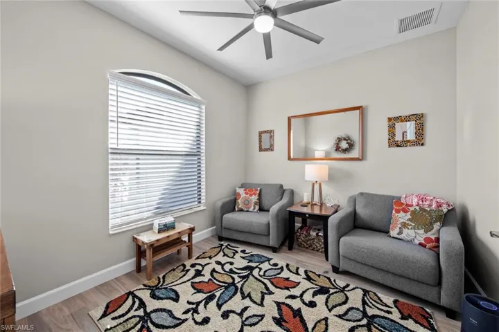 Sitting room featuring ceiling fan, lofted ceiling, and light wood-type flooring