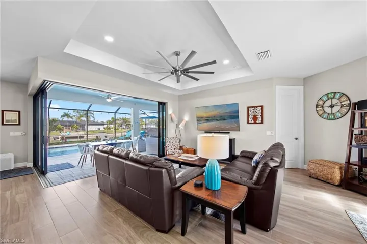 Living room with a raised ceiling and light wood-type flooring