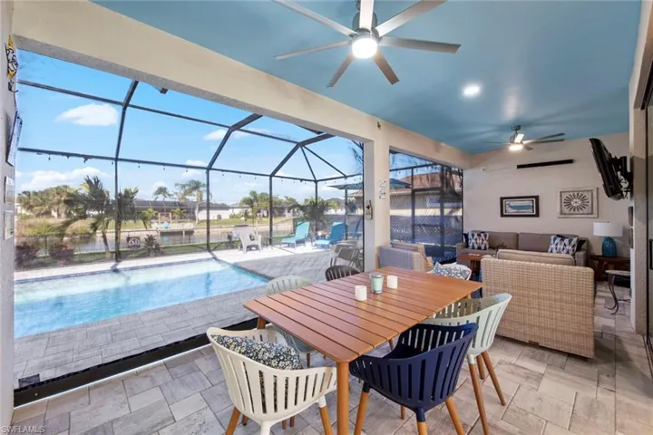 View of swimming pool with outdoor lounge area, glass enclosure, and a patio