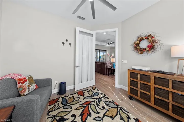 Sitting room with french doors and light wood-type flooring