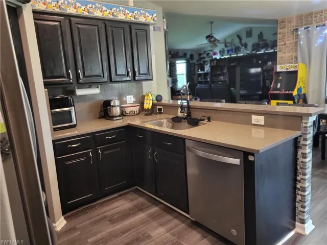 Kitchen with sink, kitchen peninsula, and appliances with stainless steel finishes