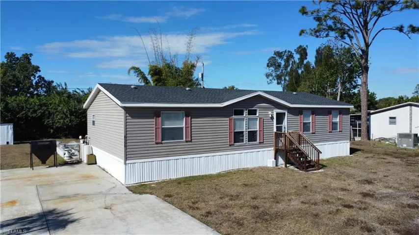Manufactured / mobile home with a front lawn and roof with shingles