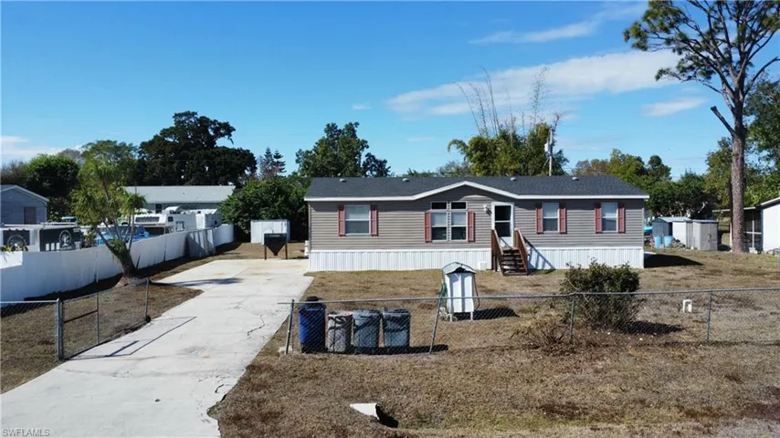Manufactured / mobile home with driveway and a fenced front yard