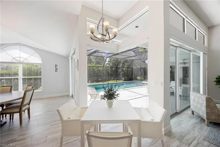 Dining area featuring a wealth of natural light, a chandelier, a sunroom, and baseboards