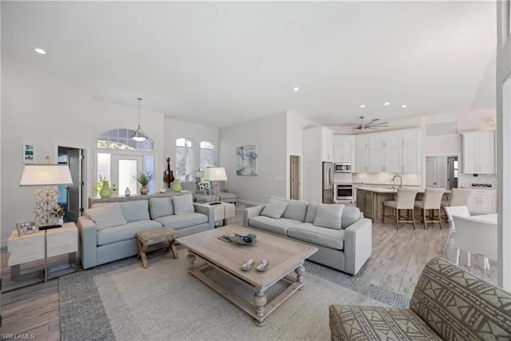 Living area with light wood-type flooring, ceiling fan, and recessed lighting