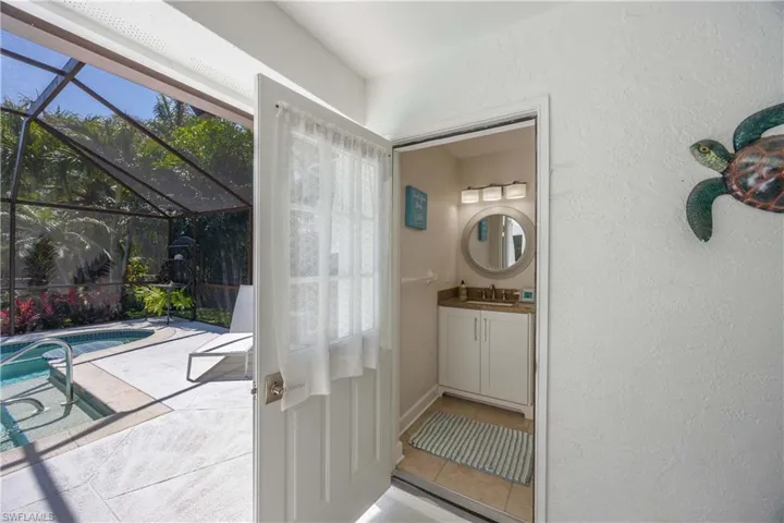 Doorway featuring a sunroom, a textured wall, and a sink