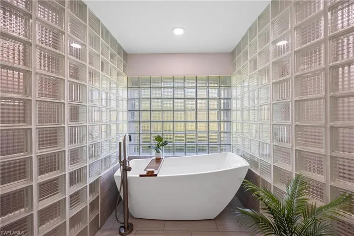 Bathroom featuring tile walls, a freestanding bath, and tile patterned flooring