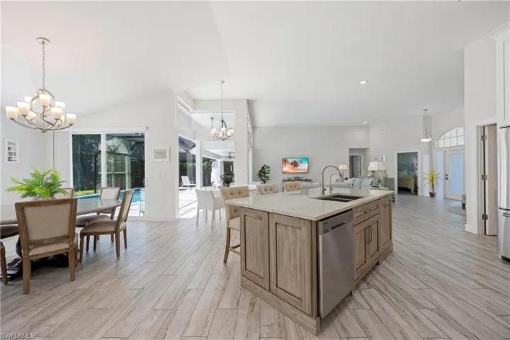 Kitchen with an inviting chandelier, plenty of natural light, appliances with stainless steel finishes, a sink, and open floor plan
