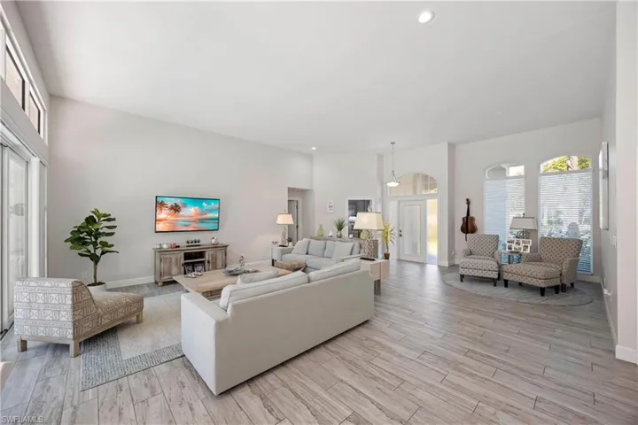 Living room featuring baseboards, recessed lighting, and light wood-style floors