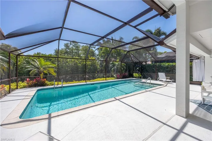 Pool featuring a patio and glass enclosure