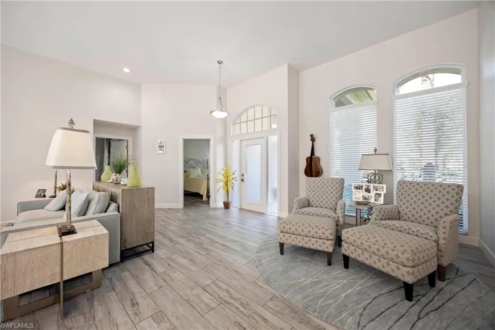 Living room with baseboards, a healthy amount of sunlight, and light wood-style floors