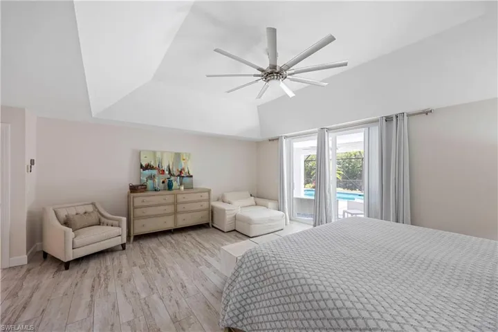 Bedroom featuring vaulted ceiling, light wood-style floors, a ceiling fan, and access to exterior
