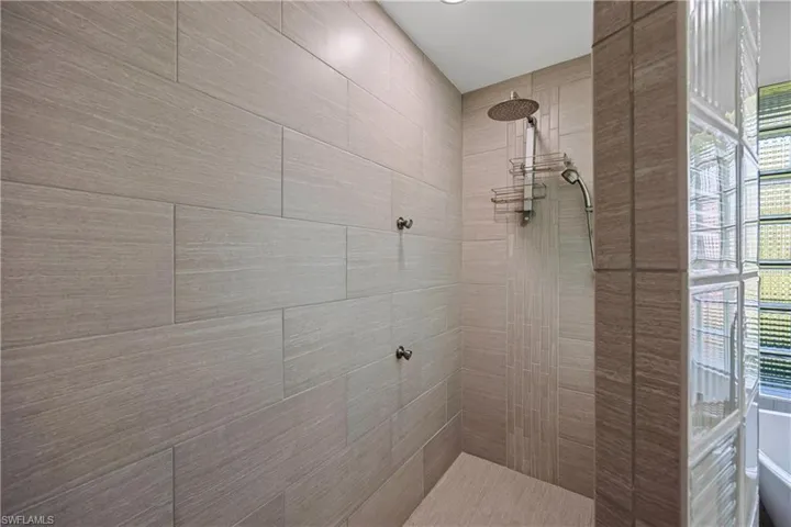 Bathroom featuring plenty of natural light and tiled shower