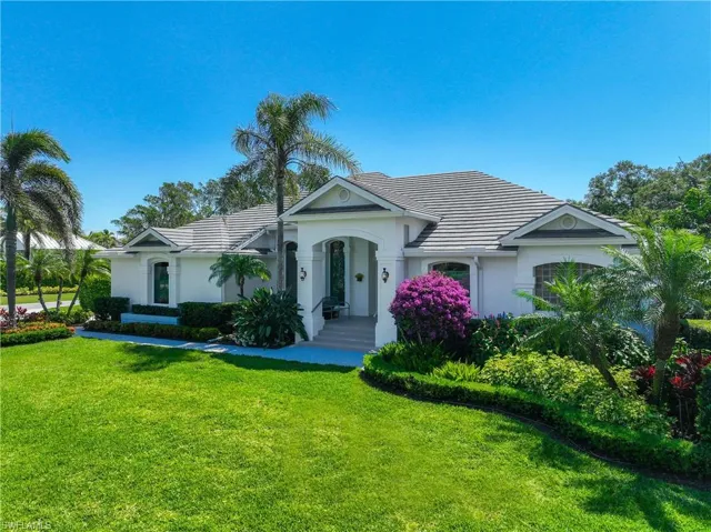 Ranch-style home featuring a tile roof, a front yard, and stucco siding
