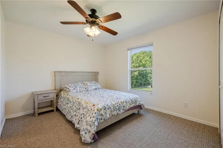 Carpeted bedroom with ceiling fan