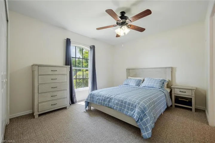 Carpeted bedroom with ceiling fan