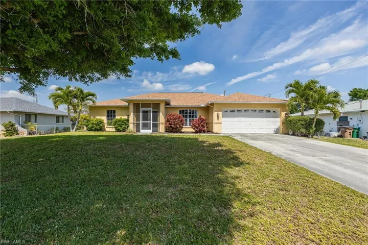 Single story home featuring a garage and a front yard