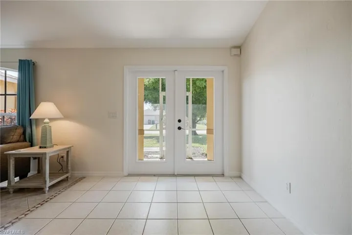 Doorway featuring a healthy amount of sunlight, light tile patterned floors, and french doors