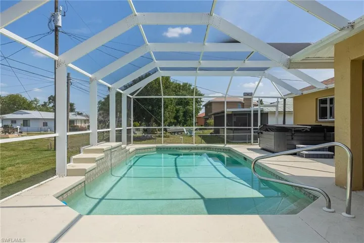View of swimming pool featuring a lawn, a lanai, a patio, and a hot tub