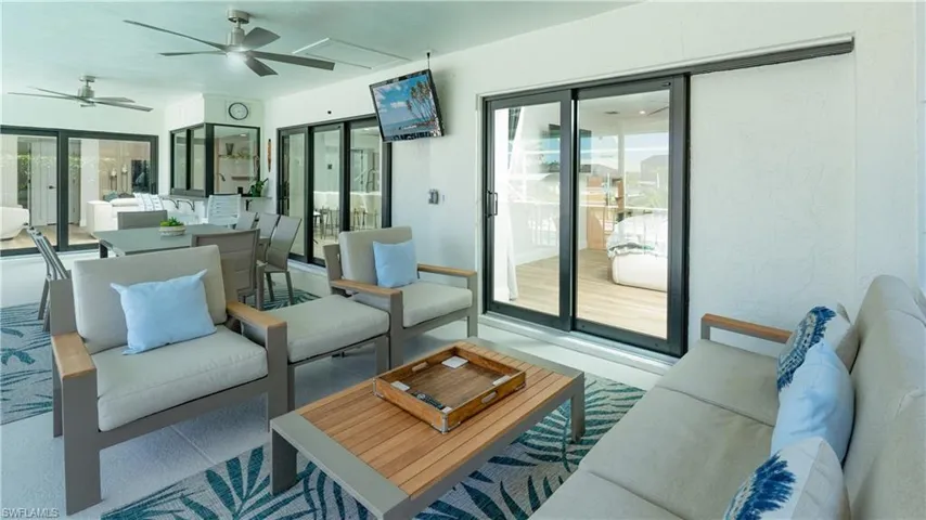 Living room with french doors, a wealth of natural light, and ceiling fan