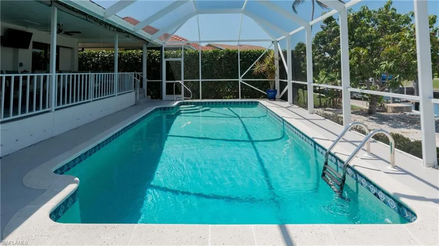 View of swimming pool with ceiling fan and a lanai