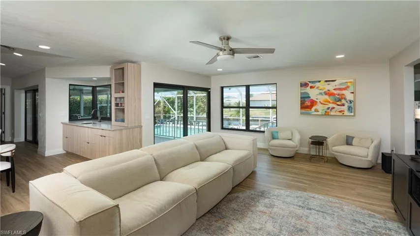 Living room with light hardwood / wood-style floors, ceiling fan, and sink