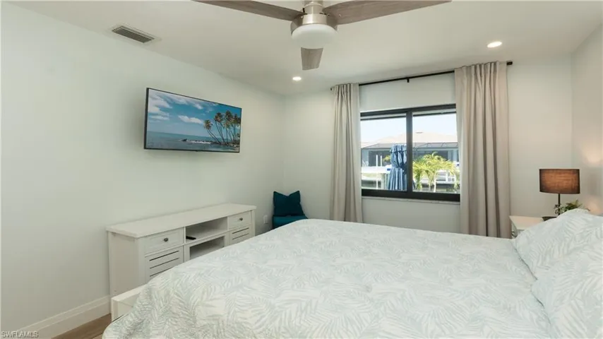 Bedroom with ceiling fan and hardwood / wood-style flooring