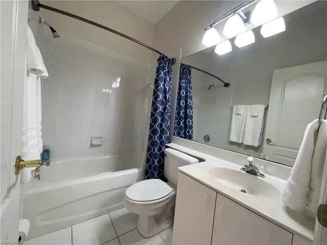 Full bathroom featuring vanity, shower / tub combo with curtain, and light tile patterned floors