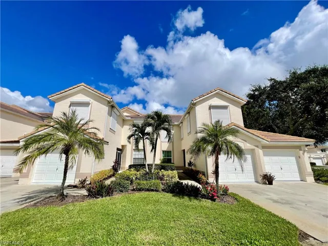 Mediterranean / spanish-style house with stucco siding, a tile roof, a front yard, and driveway