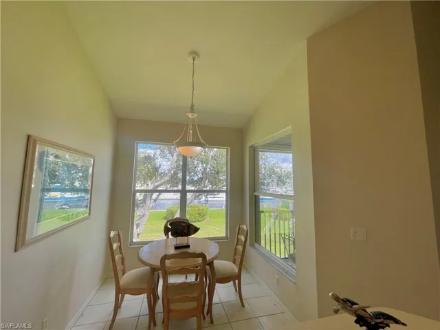 Dining area featuring light tile patterned flooring and lofted ceiling