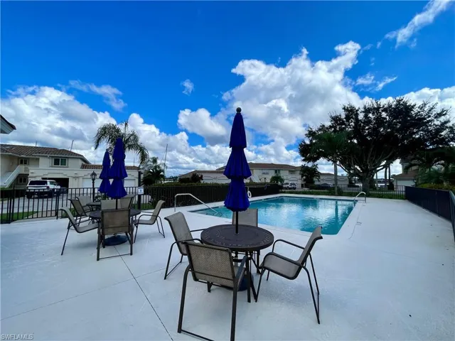 Community pool with a patio and outdoor dining area