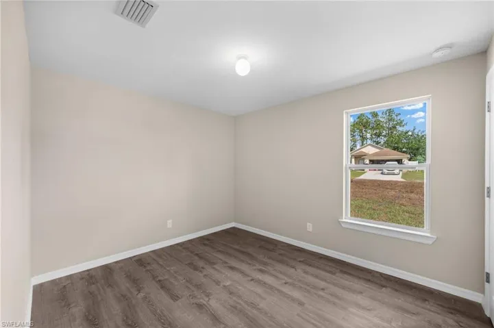 Empty room with hardwood / wood-style flooring