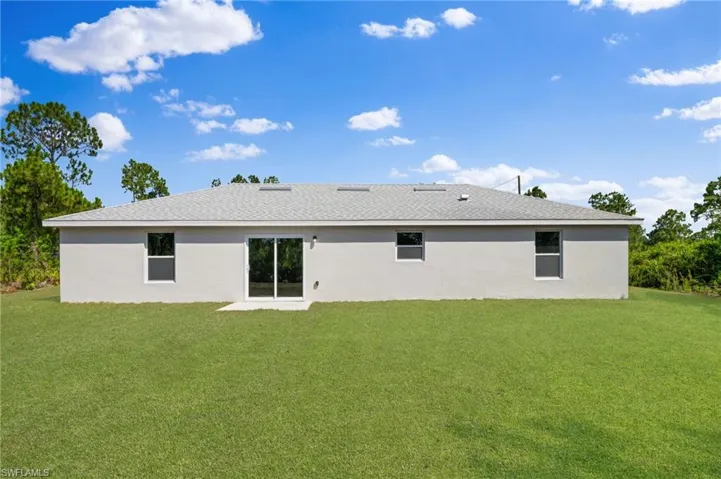 Rear view of house with a yard