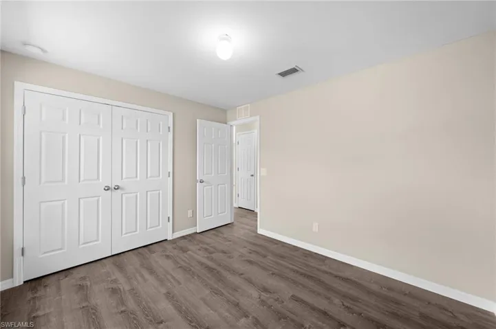 Unfurnished bedroom with a closet and hardwood / wood-style flooring