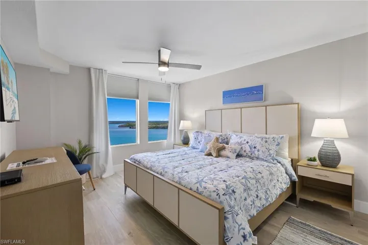 Bedroom with ceiling fan, a water view, and light hardwood / wood-style flooring