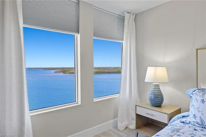 Bedroom with light hardwood / wood-style flooring and a water view
