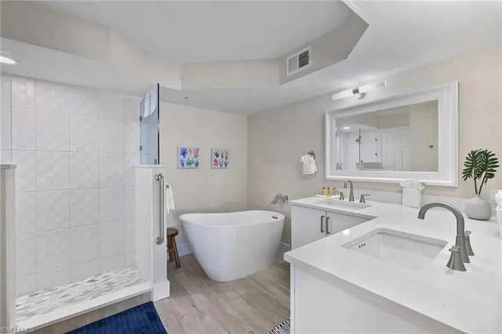 Bathroom featuring vanity and shower with separate bathtub