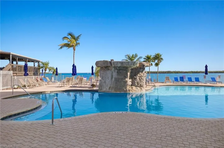 View of swimming pool featuring a water view and a patio