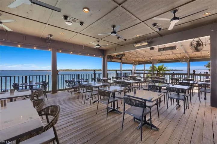 Wooden deck with ceiling fan and a water view