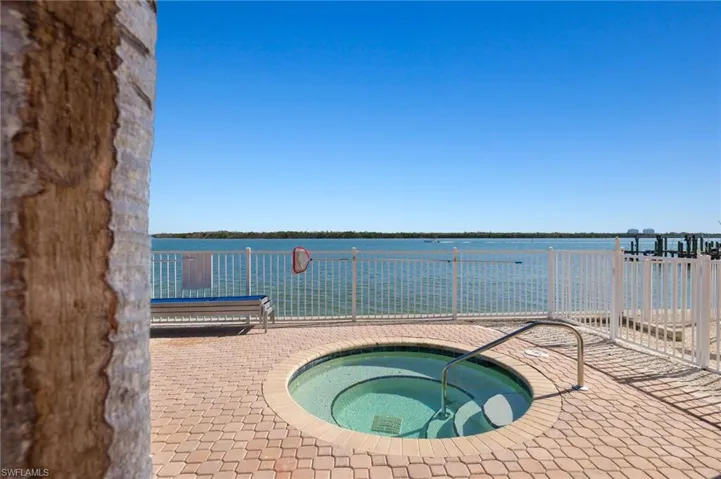 View of pool featuring a community hot tub and a water view