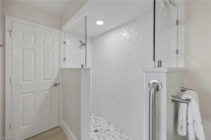Bathroom with a tile shower and wood-type flooring