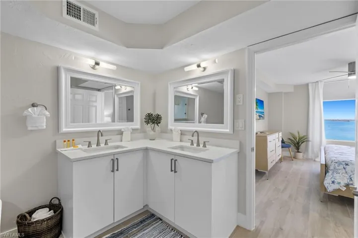 Bathroom with hardwood / wood-style flooring, vanity, ceiling fan, and a water view