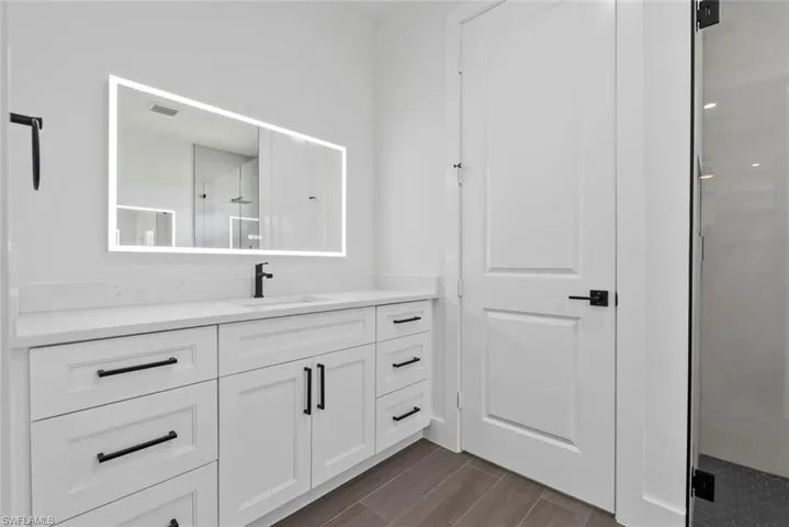 Master Bathroom with tile floors, walk in shower, and vanity