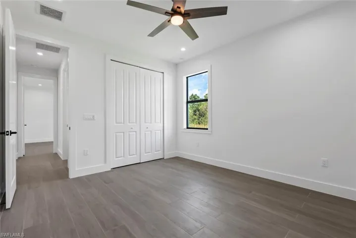 Unfurnished bedroom with a closet, ceiling fan, and hardwood / wood-style flooring